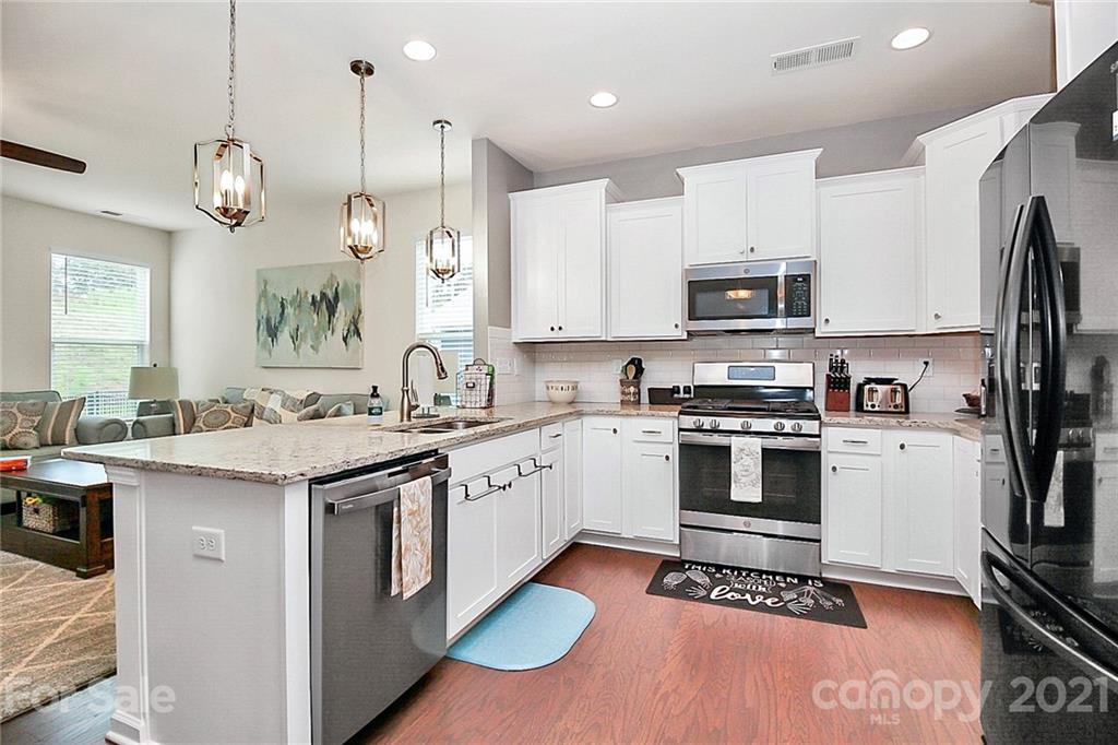 7131 Chrysanthemum Road Lancaster, SC 29720 - Photo 13 of 33 a kitchen with stainless steel appliances granite countertop a sink a stove a refrigerator and island with wooden floor