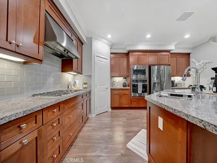 a kitchen with stainless steel appliances granite countertop wooden cabinets a sink and a counter space