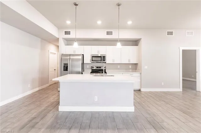 a view of kitchen with granite countertop cabinets and refrigerator