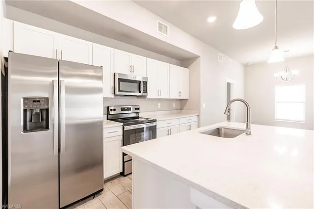 a kitchen with a refrigerator sink and cabinets