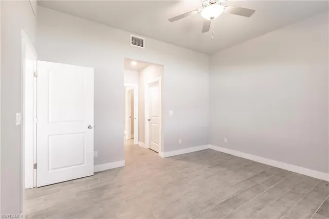 an empty room with a ceiling fan and carpet