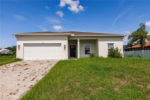 a front view of a house with a garden and yard