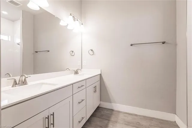 a bathroom with a double vanity sink and a mirror