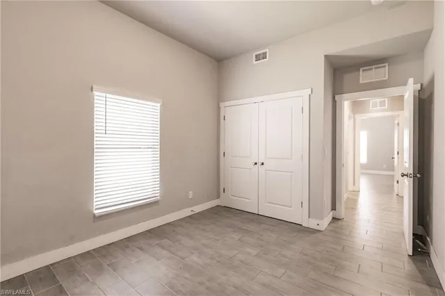 an empty room with windows and closet
