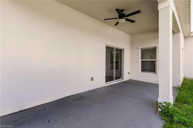 an empty room with a ceiling fan and window