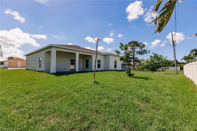 a view of a house with backyard and sitting area