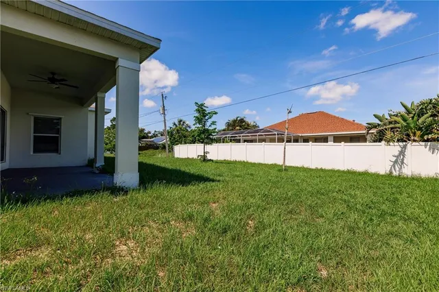 a view of a house with a backyard and a tree