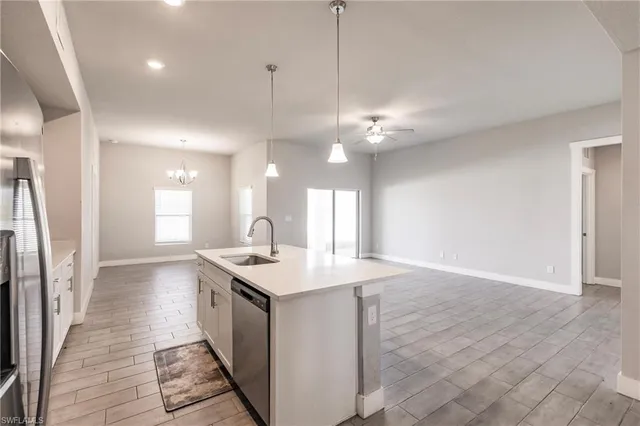 a kitchen with stainless steel appliances granite countertop a sink a refrigerator and a stove