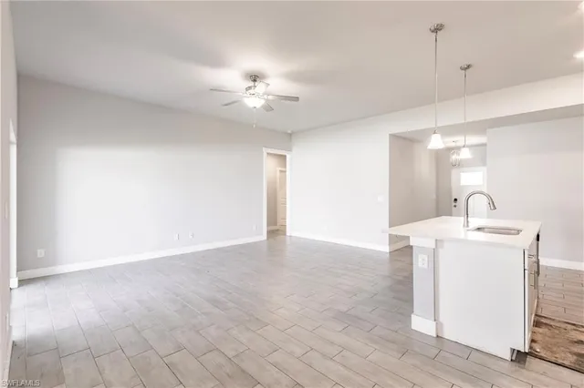 a view of a kitchen with a sink and a chandelier fan