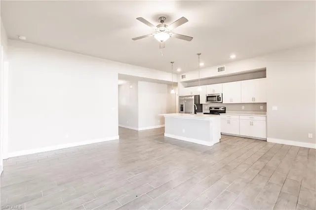 a view of kitchen with kitchen island a sink and a stove with wooden floor