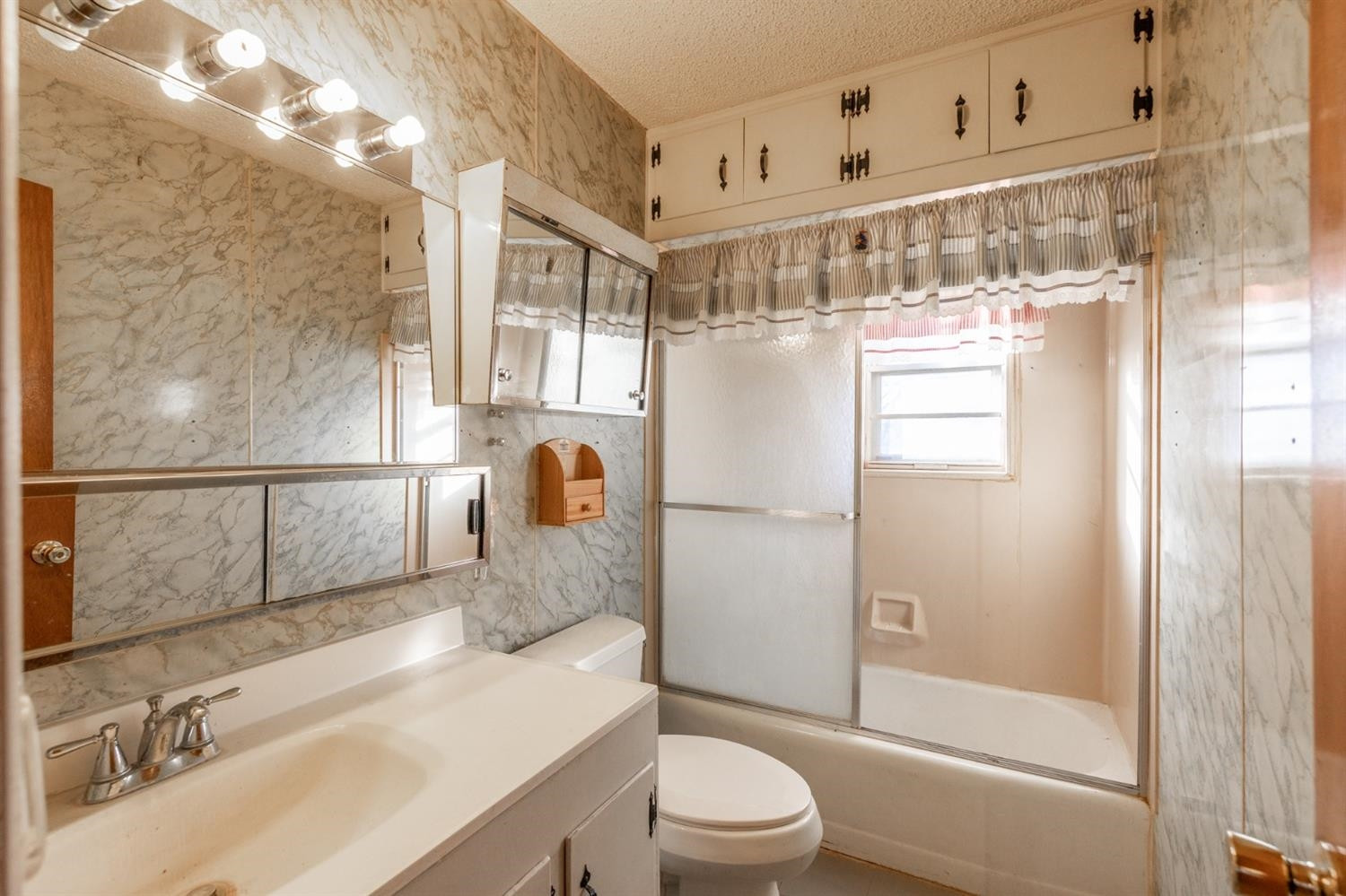 1216 10th Street Shallowater, TX 79363 - Photo 15 of 20 a bathroom with a sink a toilet and shower