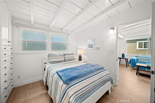 a bedroom with a bed and a dresser next to a window