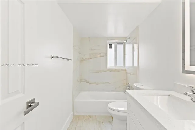 a bathroom with a toilet a sink and bathtub