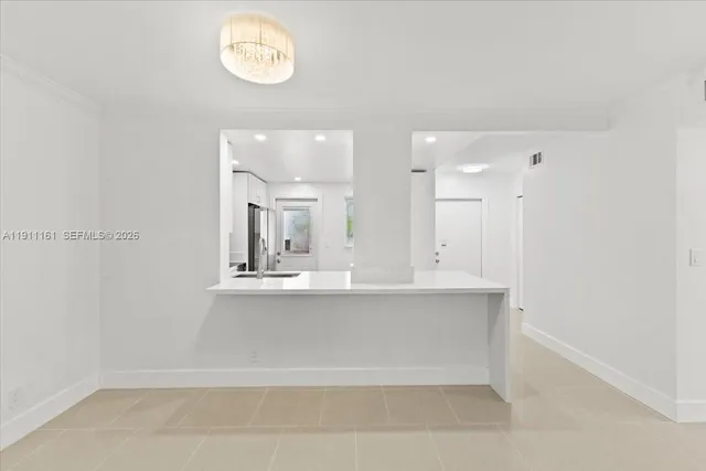 a view of kitchen with kitchen island and stainless steel appliances