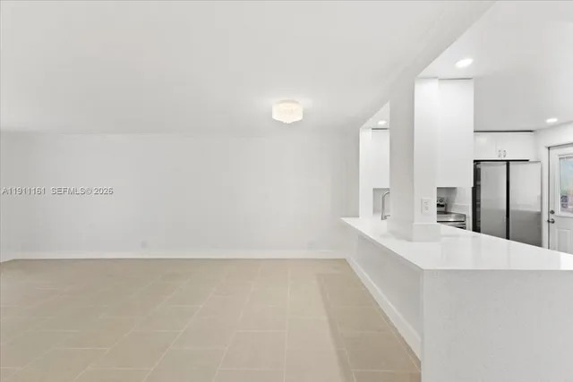 a large white kitchen with cabinets