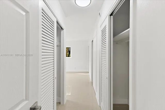 a view of a hallway with wooden floor and windows