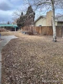 a view of a yard with wooden fence