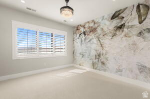 1141 East Lost Ridge Drive Washington, UT 84780 - Photo 100 of 108 Spacious room featuring a decorative accent wall, three large windows with white plantation shutters, neutral carpeting, recessed lighting, and a crystal chandelier