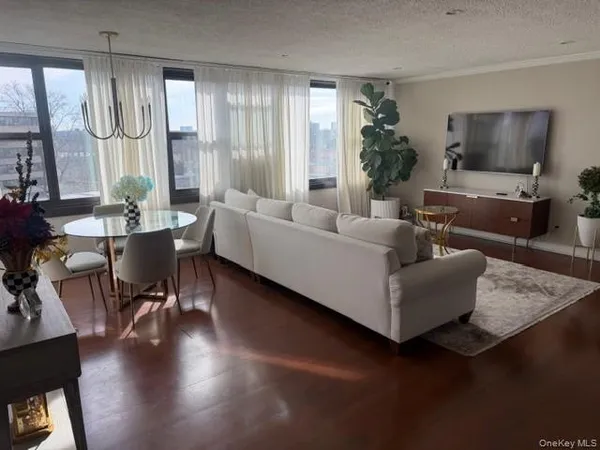 a living room with furniture wooden floor and a large window