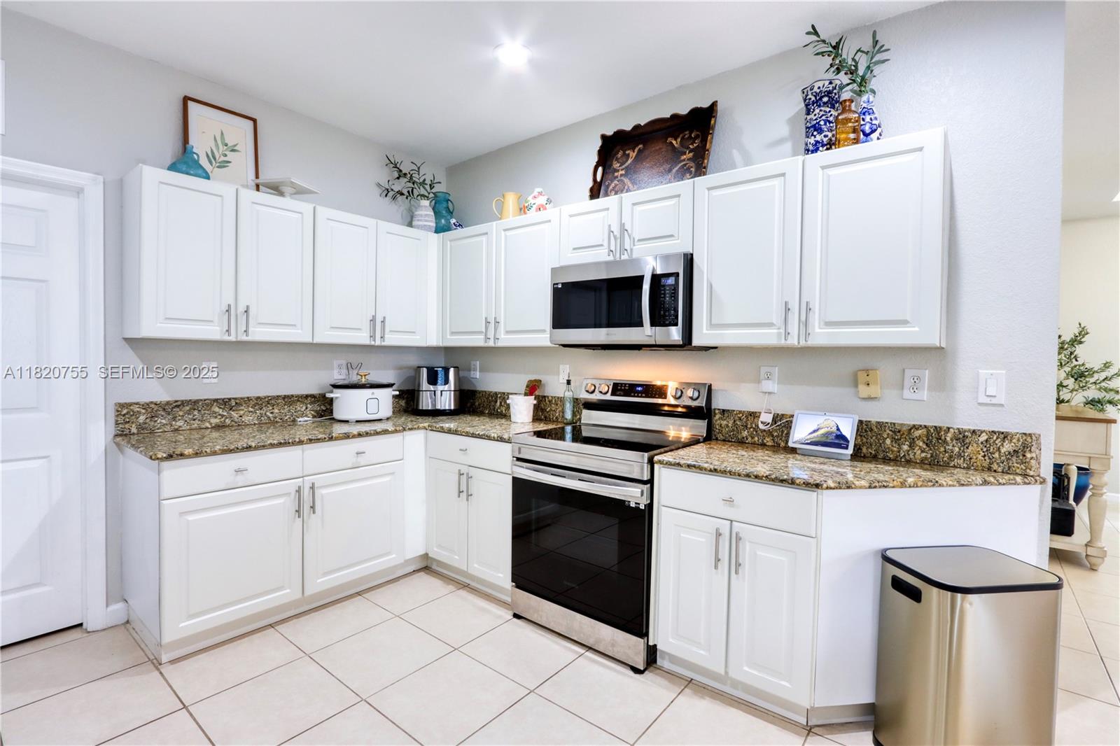 148 Northeast 36th Avenue Road Homestead, FL 33033 - Photo 19 of 53 a kitchen with stainless steel appliances granite countertop a sink and white cabinets