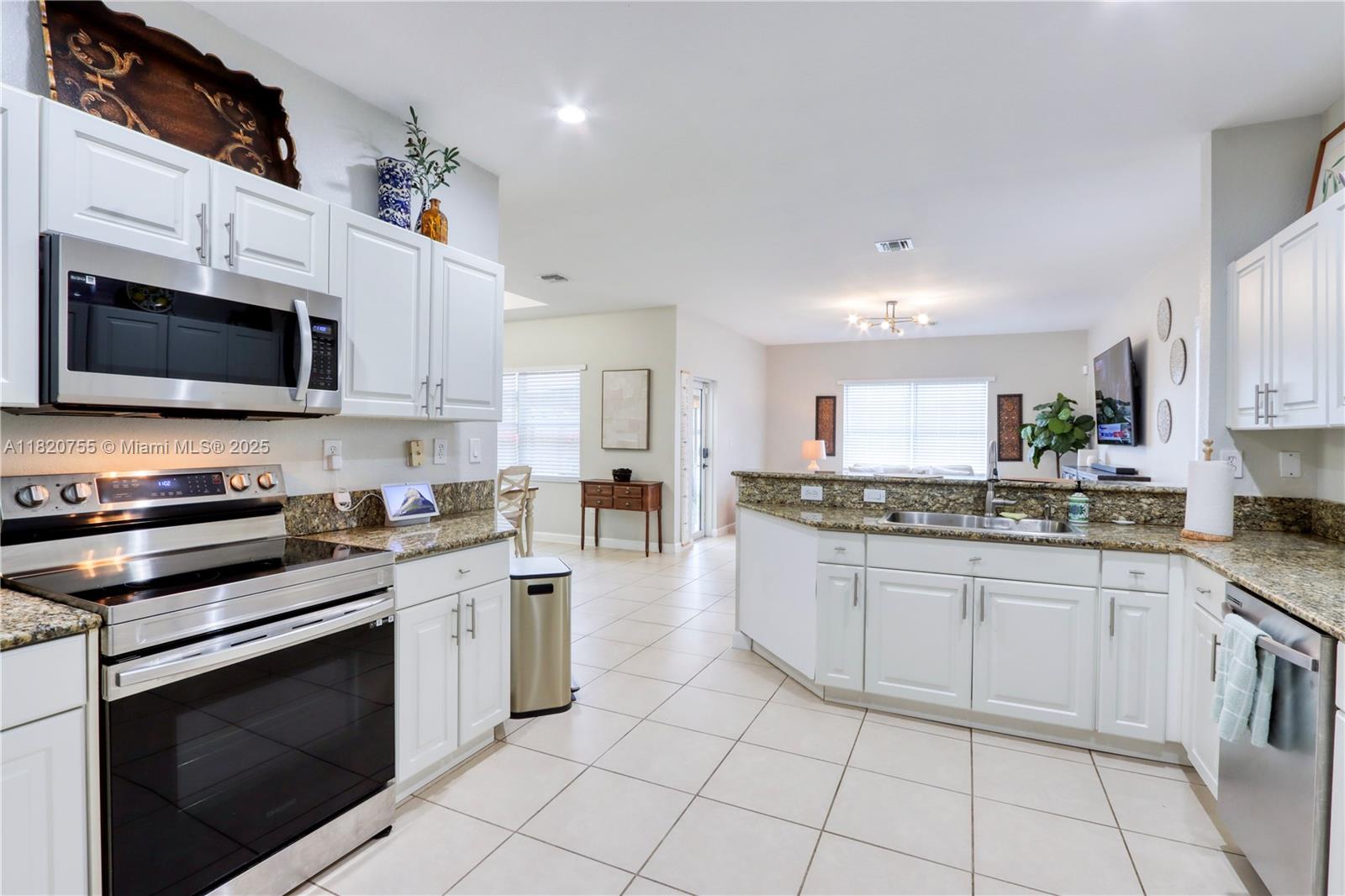 148 Northeast 36th Avenue Road Homestead, FL 33033 - Photo 20 of 53 a kitchen with granite countertop a stove top oven microwave and cabinets