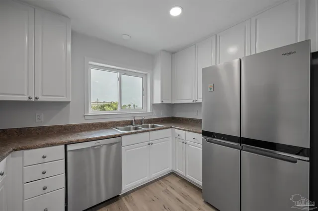 a kitchen with a refrigerator sink and cabinets