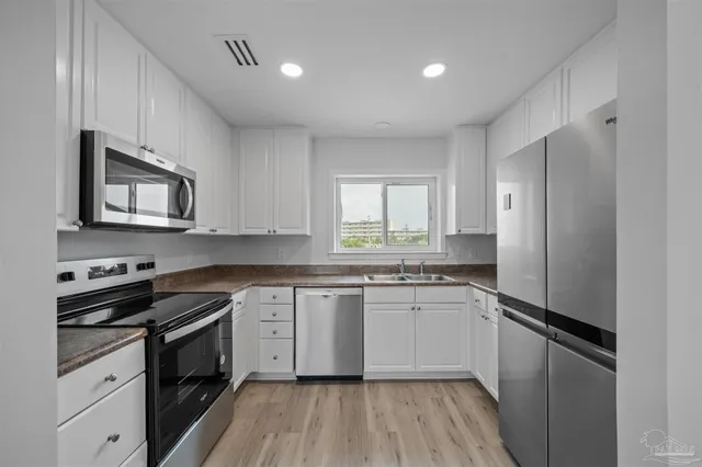 a kitchen with a sink stove cabinets and refrigerator