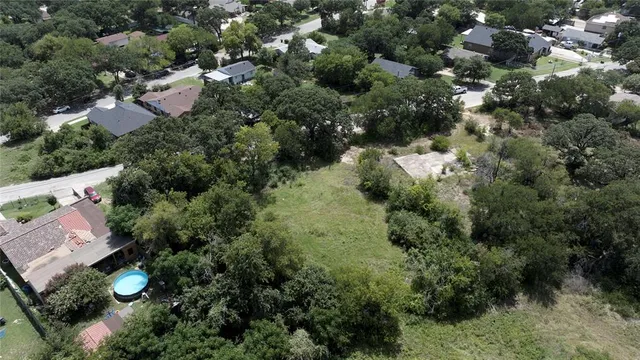 an aerial view of residential house with outdoor space and trees all around
