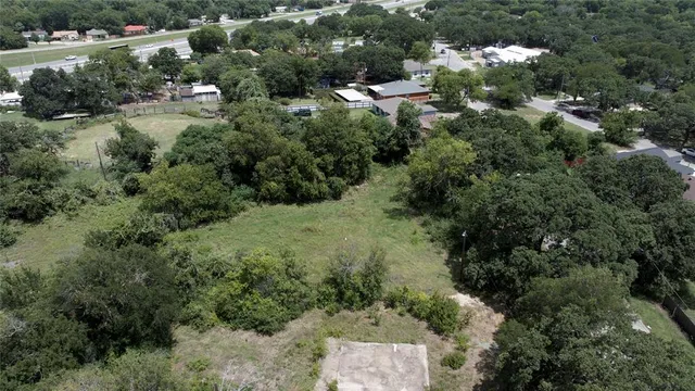 an aerial view of residential house with outdoor space and trees all around