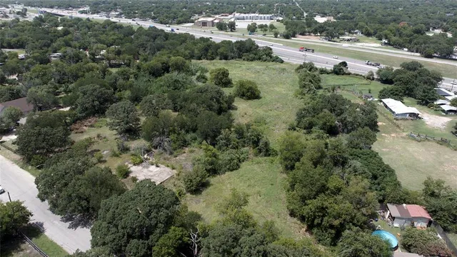 an aerial view of residential houses with outdoor space and trees