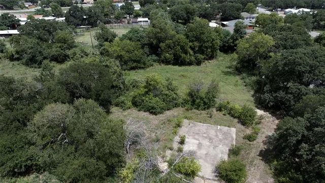 an aerial view of residential house with outdoor space and trees all around
