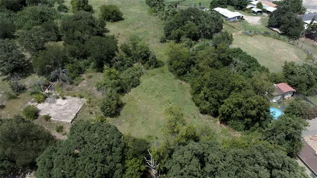an aerial view of residential house with outdoor space and trees all around