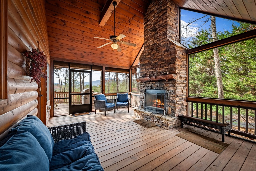126 Sugar Mountain Road Blue Ridge, GA 30513 - Photo 12 of 78 a living room with furniture a fireplace and a floor to ceiling window