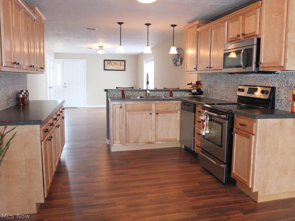 5251 Taylor Road Atwater, OH 44201 - Photo 4 of 20 Completely updated kitchen with tile backsplash and stainless steel oven, range and over the range microwave.
