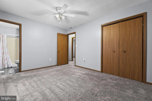 a view of an empty room with a chandelier fan