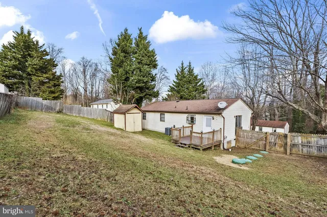 a front view of a house with a yard and large tree