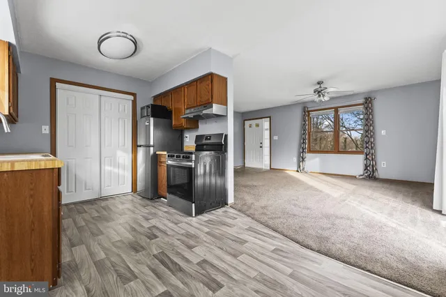 a view of a kitchen with wooden floor and a refrigerator
