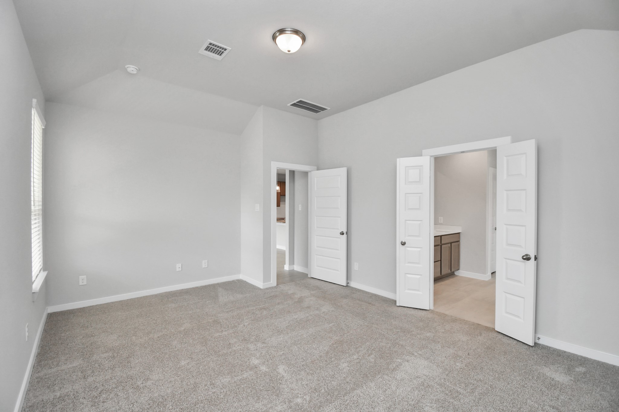 14606 Surfbird Lane Houston, TX 77049 - Photo 20 of 45 Come and unwind after a long day in this magnificent primary suite! This spacious room features plush carpet, warm paint, high ceilings and large windows with privacy blinds.