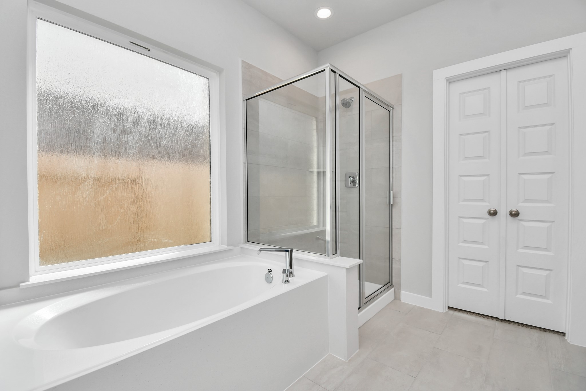 14606 Surfbird Lane Houston, TX 77049 - Photo 24 of 45 Indulge in a spa-like retreat within the confines of this primary bathroom. Delight in a spacious walk-in shower enveloped in stylish tile surround and unwind in a separate garden tub adorned with custom detailing.