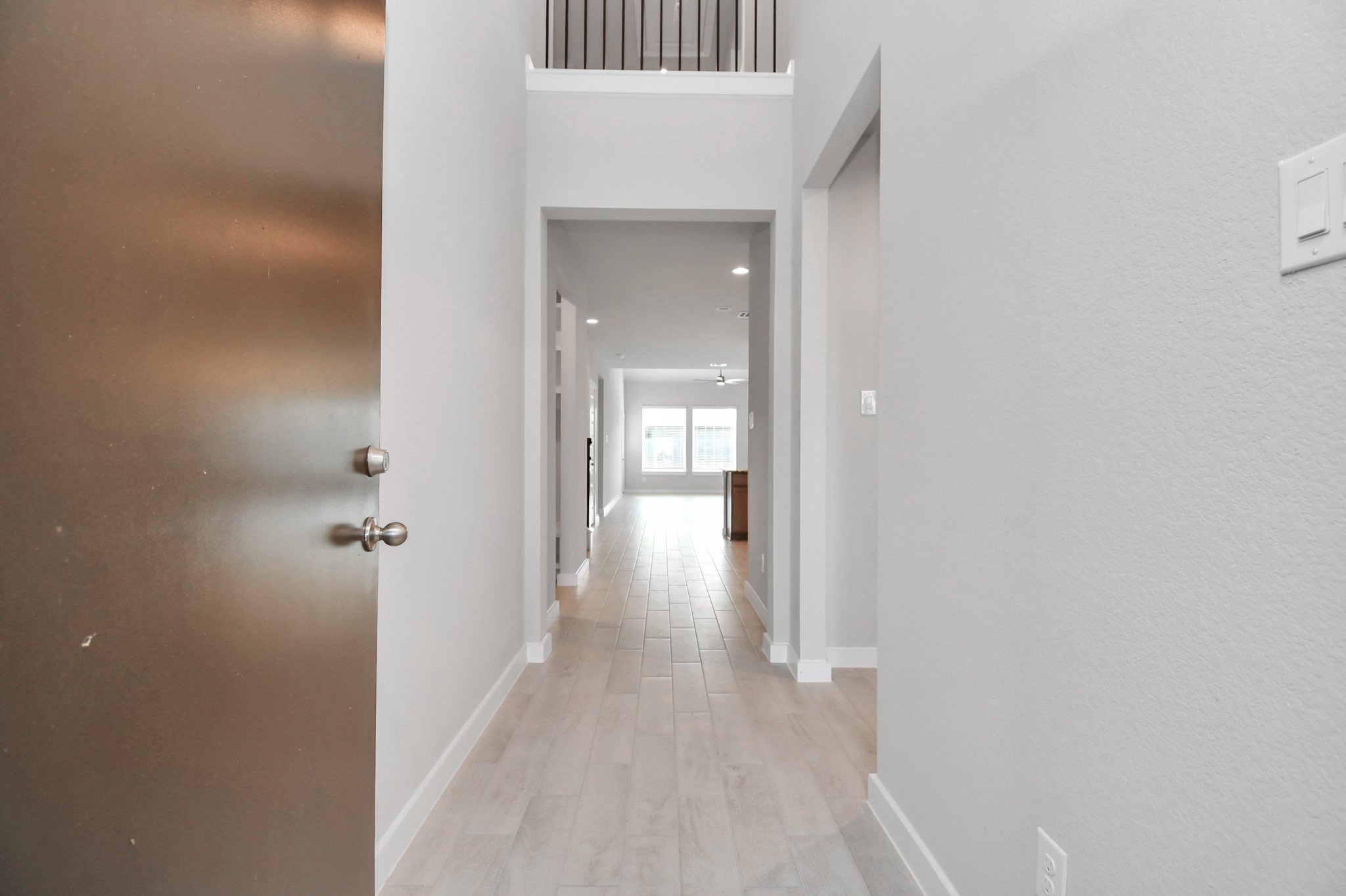14606 Surfbird Lane Houston, TX 77049 - Photo 6 of 45 As you step into the threshold of this luxurious home, you'll soon be welcomed by an elegant glass door (to be installed). Inside, soaring ceilings amplify the spaciousness, while the refined wood-look tile flooring and oversized baseboards exude sophistication and charm.