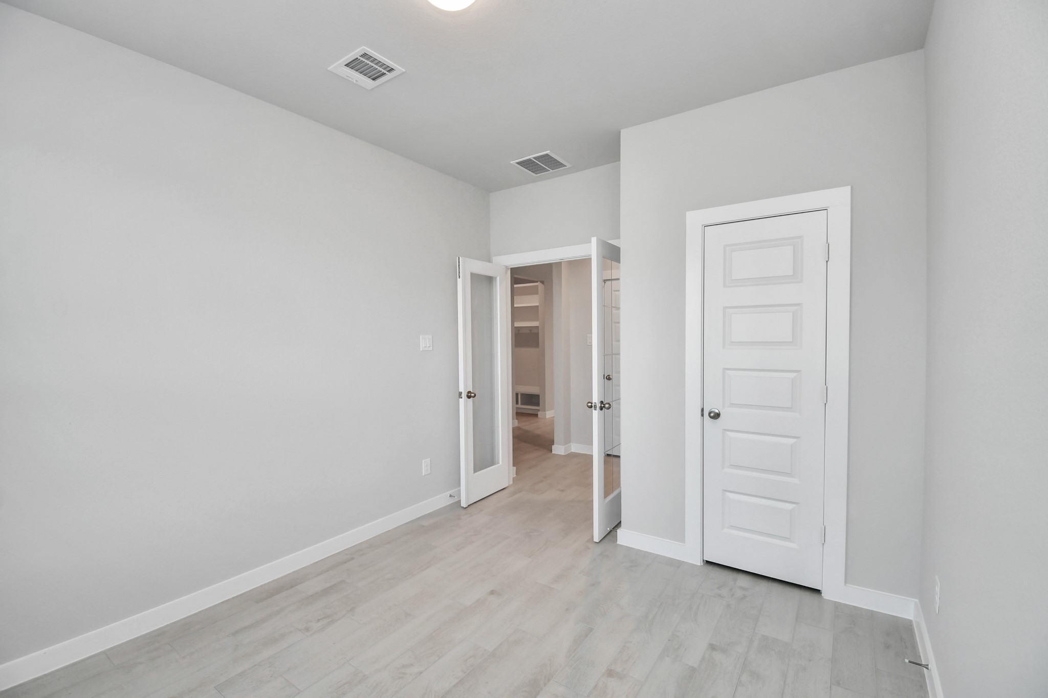 14606 Surfbird Lane Houston, TX 77049 - Photo 7 of 45 Experience the perfect blend of sophistication and warmth in this home office, boasting elegant wood-look tile flooring and flooded with natural light from expansive windows and French doors.