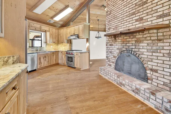 a kitchen with granite countertop a stove a sink dishwasher and a oven
