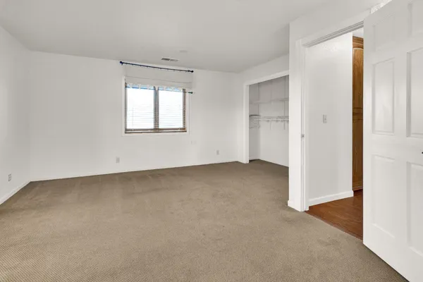 an empty room with a windows and closet