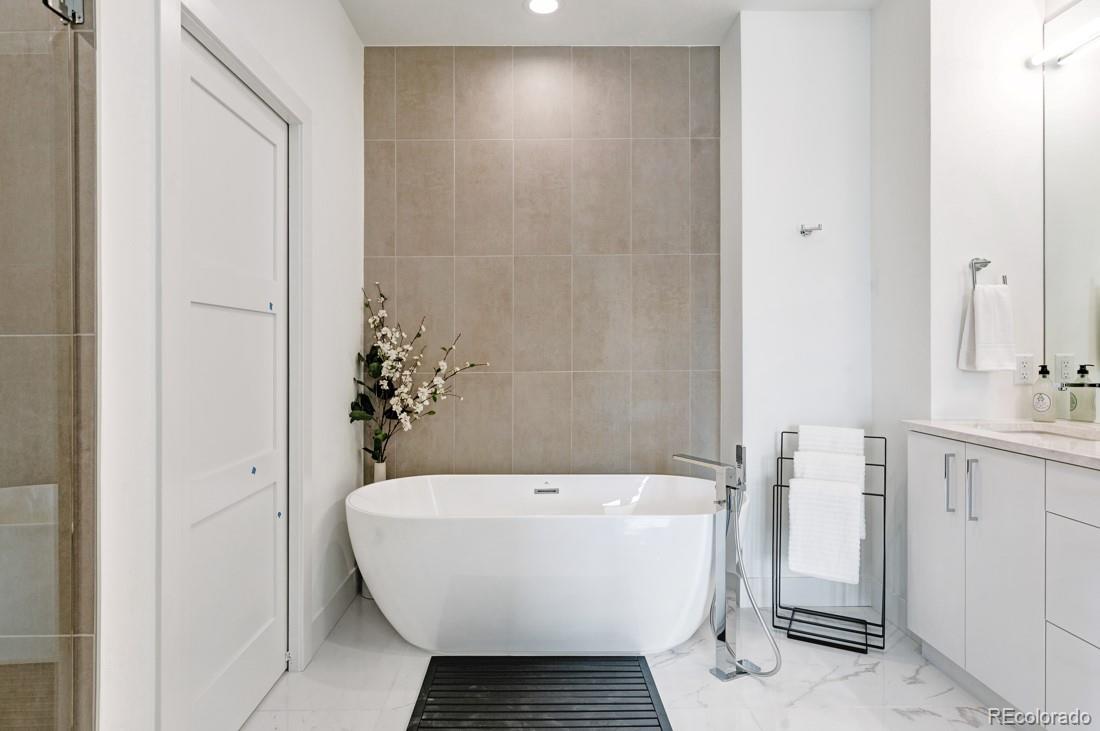 838 Ash Street, Unit 6 Denver, CO 80220 - Photo 23 of 40 a bathroom with a white tub shower sink and mirror