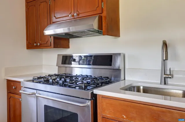 a kitchen with stainless steel appliances granite countertop a sink and a stove