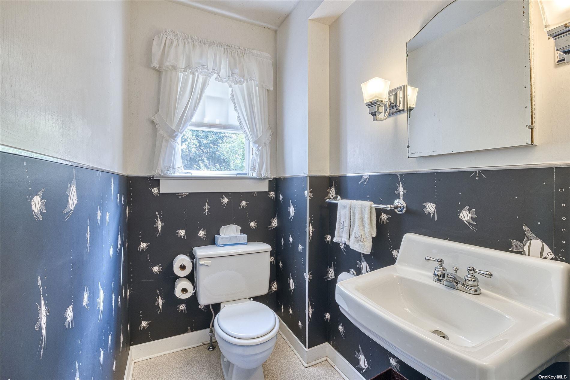 1695 Old Wood Path Southold, NY 11971 - Photo 13 of 32 a bathroom with a sink toilet and a mirror