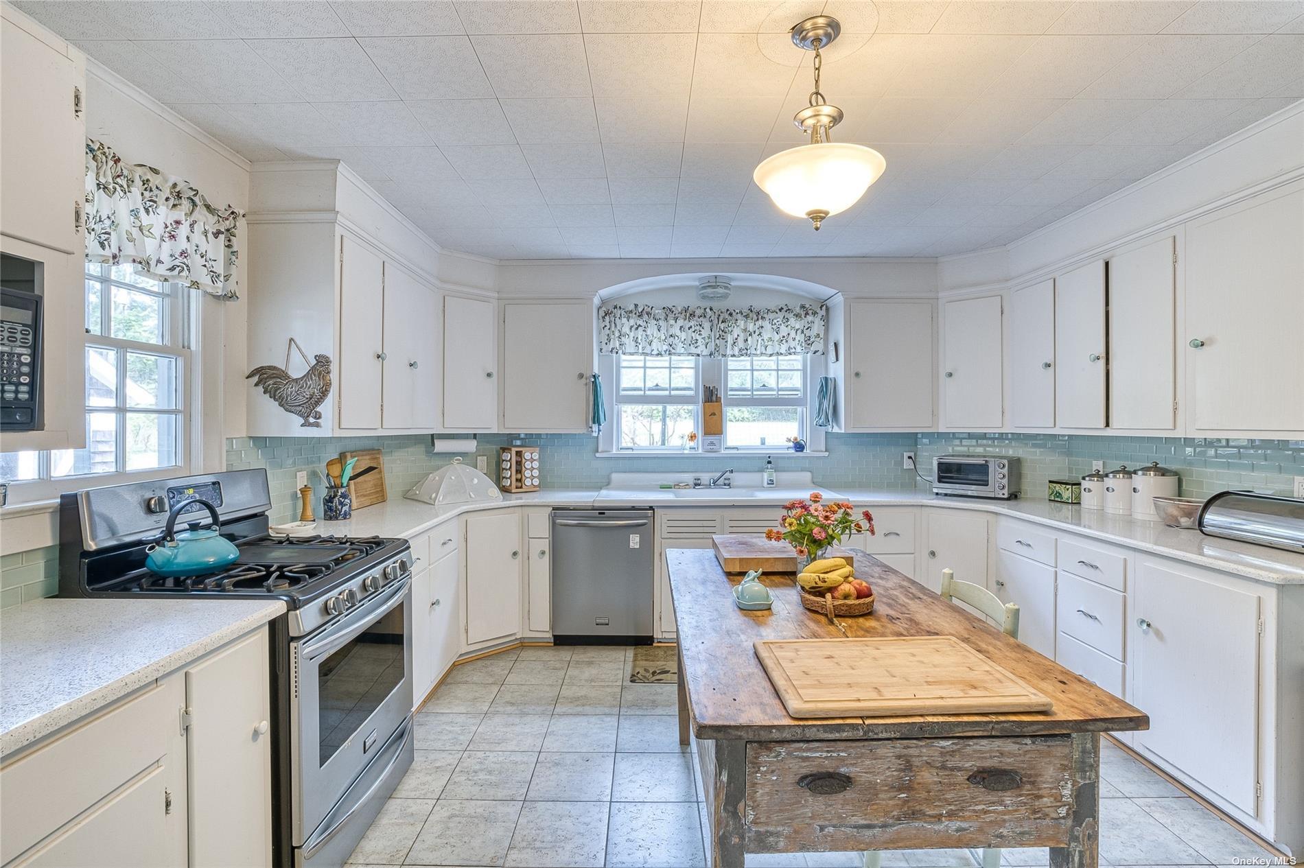 1695 Old Wood Path Southold, NY 11971 - Photo 15 of 32 a kitchen with a stove sink and cabinets