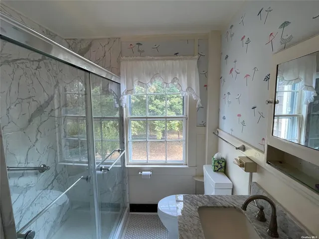 a bathroom with a granite countertop sink mirror bathtub and toilet