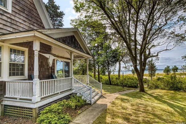 a view of a house with a small yard and wooden fence