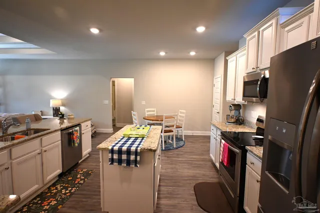 a kitchen with a stove top oven a sink a dining table and chairs